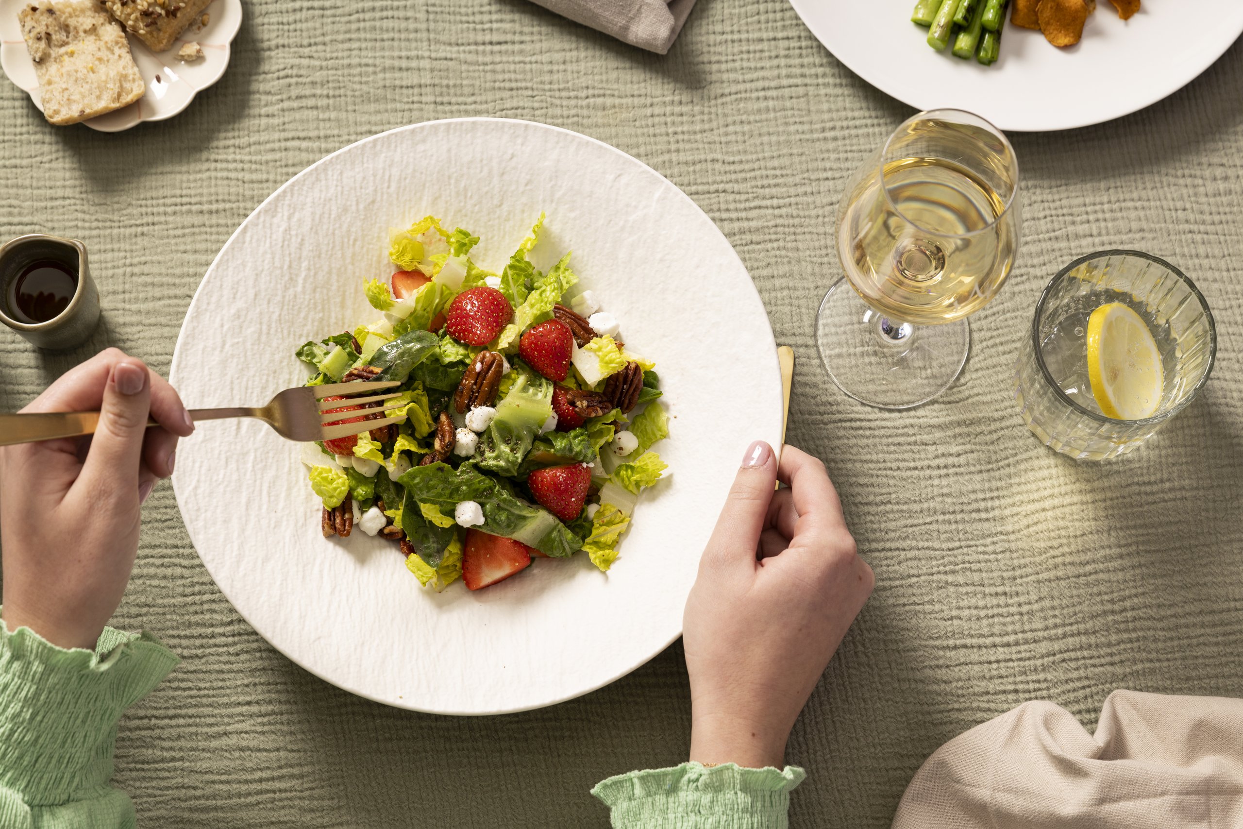 Salat mit Erdbeeren und einem Glas Wein