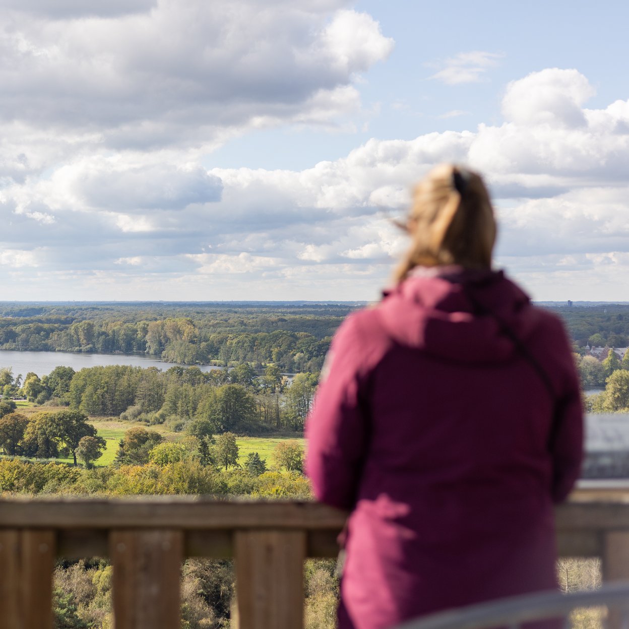 Eine Frau blickt auf eine Flusslandschaft in Limburg.