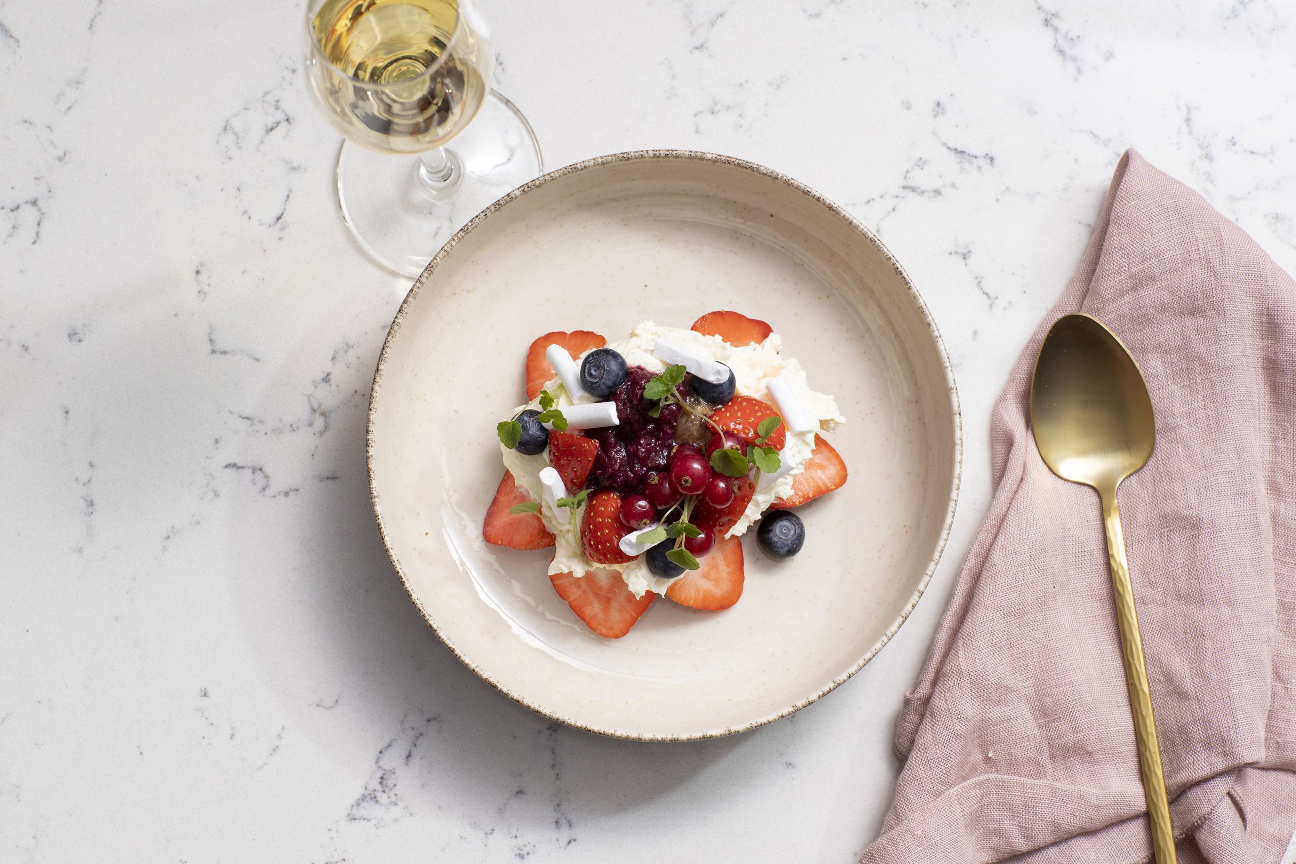 Dessert met aardbeien op een mooi bord met blauwe bessen en rood fruit