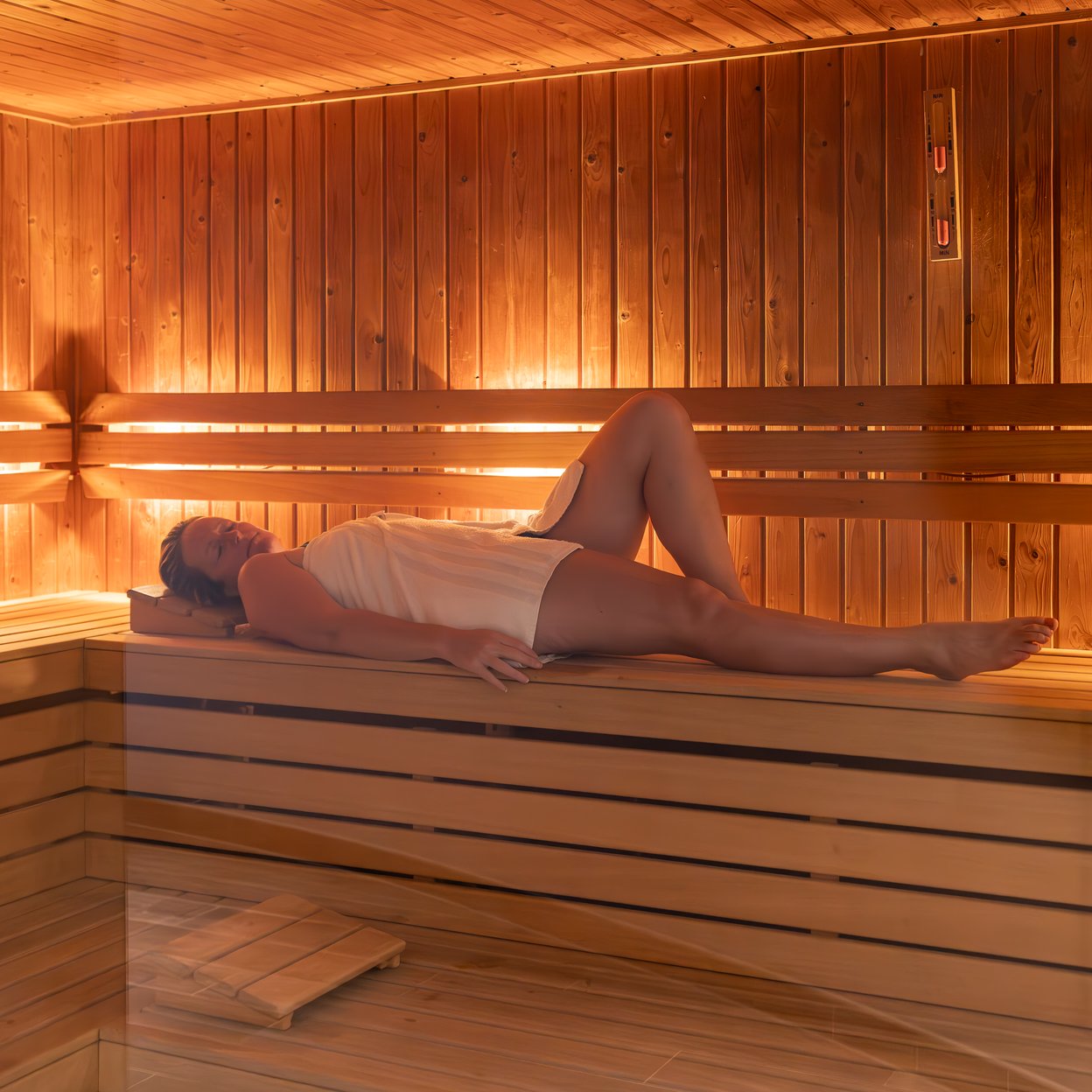 Reclining woman with towel in the sauna of Wellness Centre Vaalsbroek.