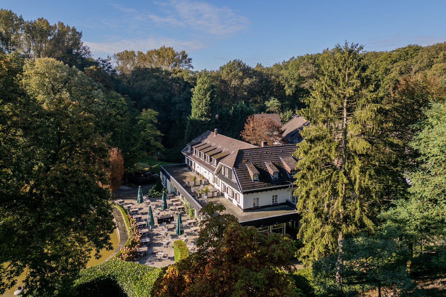 Luchtfoto van Hotel De Bovenste Molen, omringd door het groene bosgebied van Jammerdal.