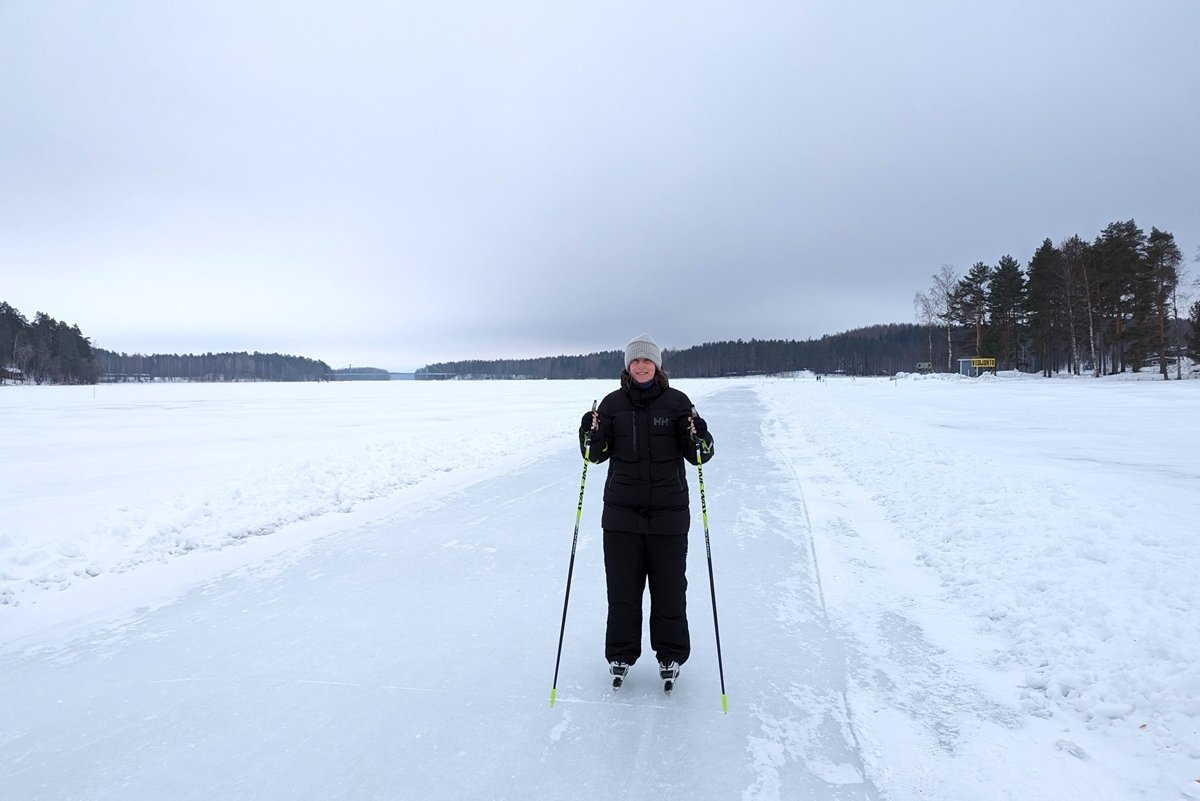 Sandra schaatst op een bevroren meer in Punkaharju, omringd door een besneeuwd landschap, momenten die bijdragen aan het hygge-gevoel zoals geïnspiree